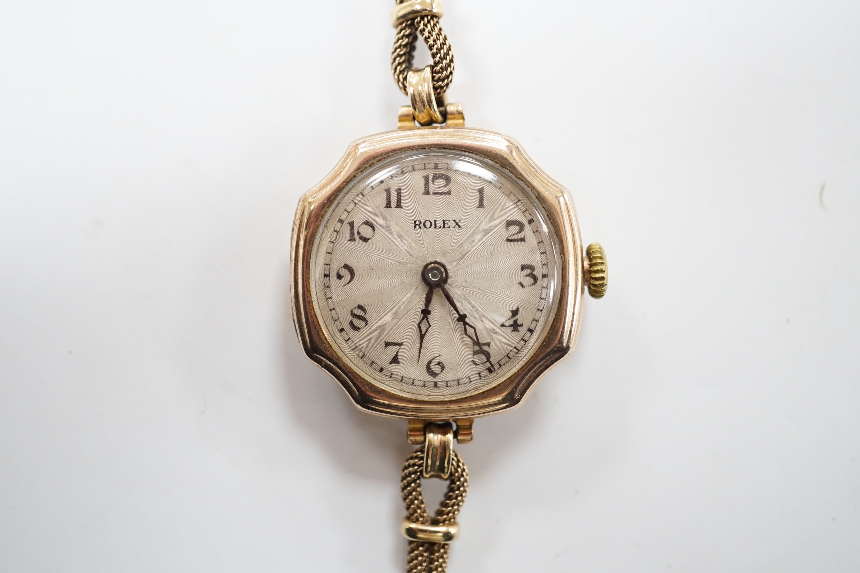 A lady's 1920's 9ct gold Rolex manual wind wrist watch, with sunburst Arabic dial, on a 9ct twin strand Vertex bracelet, gross weight 18.8 grams.